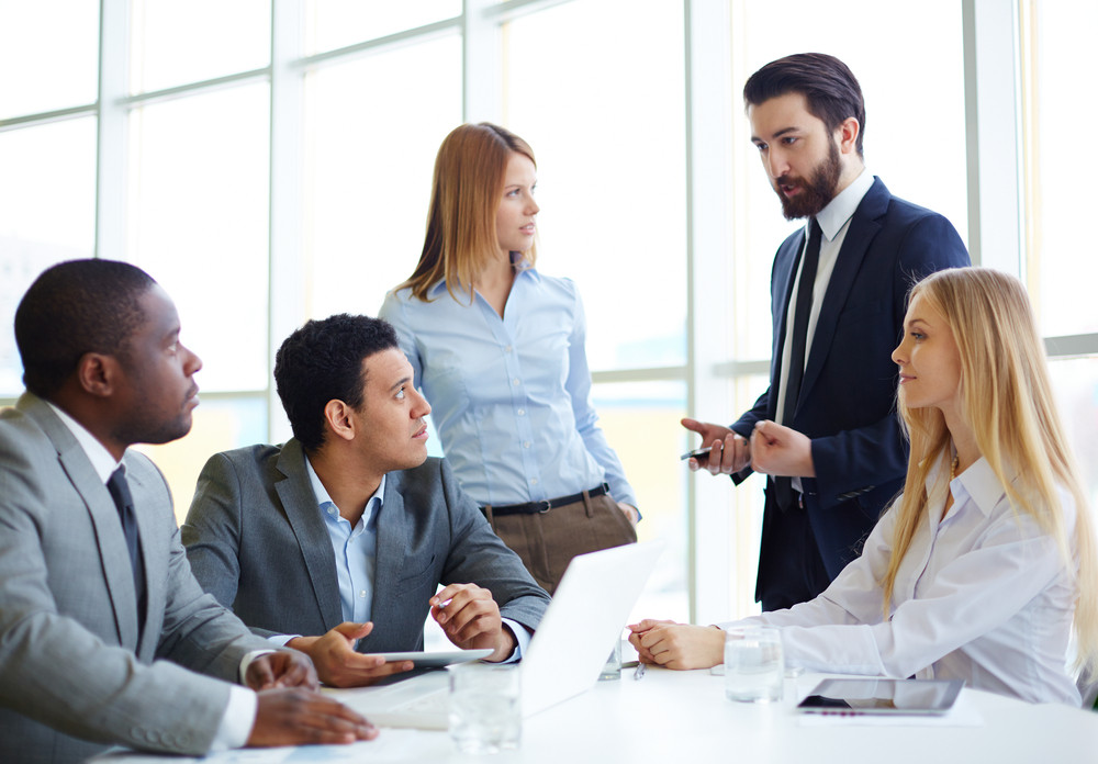 Group of business partners discussing ideas at meeting in office